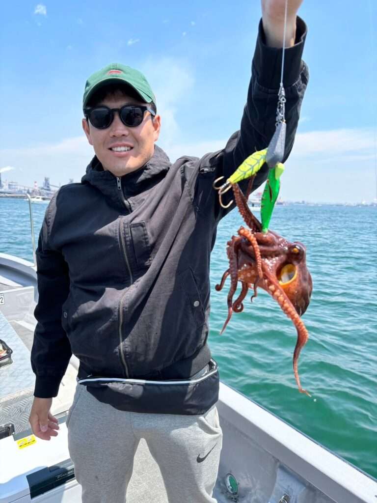 遊漁船で釣れた明石タコをもつ笑顔の釣り人