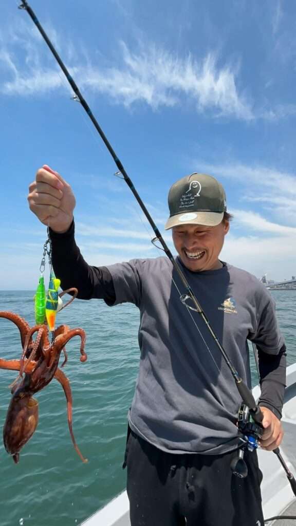 遊漁船で釣れた明石タコをもつ笑顔の釣り人